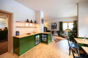 a kitchen with green cabinets and a christmas tree at Hotel Sonnwendhof Engelberg in Engelberg