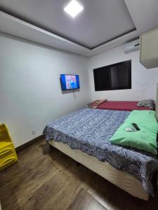 a bedroom with a bed and a flat screen tv at Casa 4 quartos com piscina em Aparecida de Goiania in Aparecida de Goiânia +32 photos