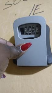a hand with a red fingernail holding a remote control at Cozy Kipepeo Cottage in Nairobi