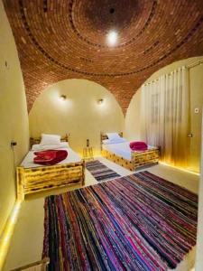 a bedroom with two beds and a large rug at The Green Mirage free pickup in Siwa