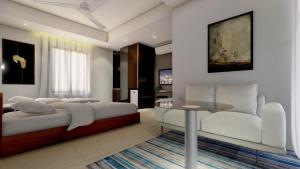a bedroom with a bed and a table and a couch at White Park Boutique Hotel in Chittagong