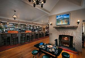 eine Bar mit Kamin und eine Bar mit Barhockern in der Unterkunft Monks Ballyvaughan in Ballyvaughan