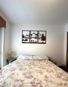 a bedroom with a bed with four pictures on the wall at Cesira in Mareson