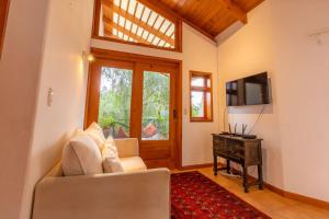 a living room with a couch and a television at Casa Tropical Atitlán in Panajachel