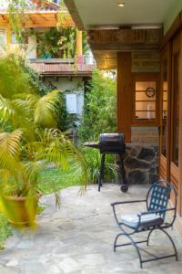 a patio with a grill and two chairs and plants at Casa Tropical Atitlán in Panajachel