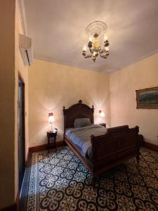 a bedroom with a bed and a chandelier at Posada La Pastora Colonial in Caracas