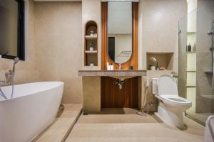 a bathroom with a tub and a toilet and a sink at Casa Miera in Bandung +6 photos