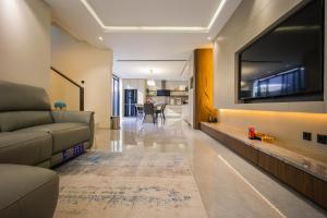 a living room with a couch and a flat screen tv at Casa Miera in Bandung