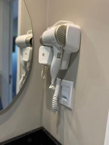 a hair dryer on a wall next to a mirror at Hotel Maravilha in Caçapava do Sul