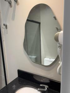 a bathroom with a mirror and a sink at Hotel Maravilha in Caçapava do Sul