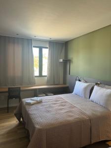 a bedroom with a large bed and a window at Hotel Maravilha in Caçapava do Sul