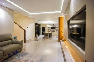 a living room with a couch and a large television at Casa Miera in Bandung