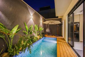 an indoor swimming pool with an umbrella in a house at Casa Miera in Bandung