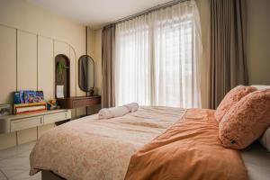 a bedroom with a large bed and a window at Casa Miera in Bandung