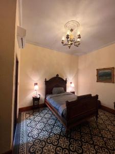 a bedroom with a bed and a chandelier at Posada La Pastora Colonial in Caracas +2 photos