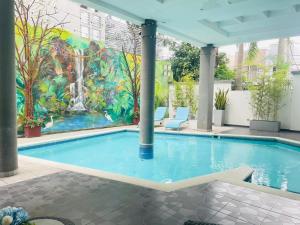 a swimming pool with a mural of a waterfall at Hotel Galerias HN in San Pedro Sula