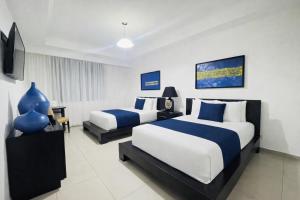 a hotel room with two beds and a television at Hotel Galerias HN in San Pedro Sula +21 photos