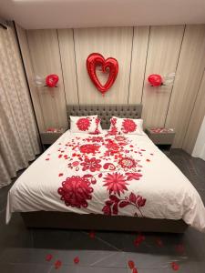 a bedroom with a bed with a red heart on the wall at Casa del jazmin Kfarabida in Kafr ‘Ubaydā