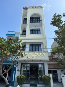 a tall white building with a sign on it at Amazon Hotel in Phước Hậu (1)