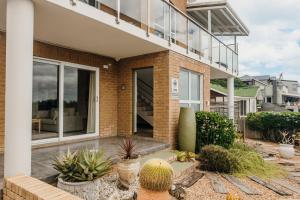 a brick house with a courtyard with plants at House Olive in De Kelders