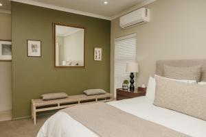 a bedroom with a large bed and a mirror at House Olive in De Kelders