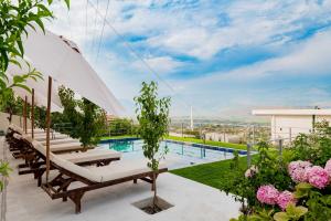 a pool on the roof of a building with chairs and an umbrella at Dashamiri's Villa in Sarandë +2 photos