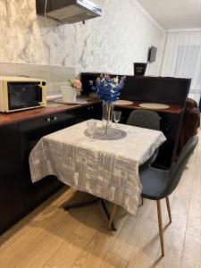 a table with a vase of flowers on it in a kitchen at Апартамент с джакузи in Khmelnytskyi