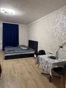 a bedroom with a bed and a table and chairs at Апартамент с джакузи in Khmelnytskyi