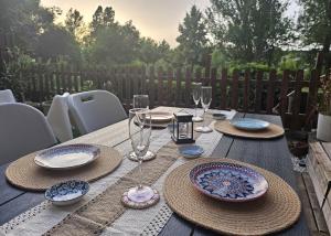 a wooden table with plates and wine glasses on it at Casa Gomez in Santa Cilia de Jaca