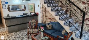 a living room with a blue couch and a staircase at Hostal Casa de las Americas in Cartagena de Indias