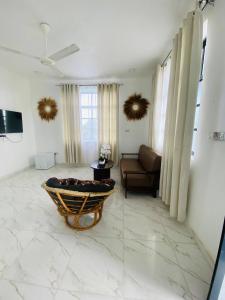 a living room with a couch and a chair at Terrys villa pool view room in Kidoti
