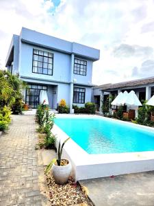 a house with a swimming pool in front of it at Terrys villa pool view room in Kidoti