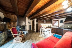 a living room with a red couch and a kitchen at La Lune de Saint George in Hone