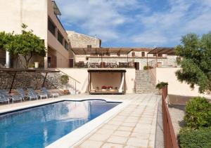 ein Haus mit Swimmingpool im Garten in der Unterkunft Hotel Can Riera by CheelHotels in Moscari
