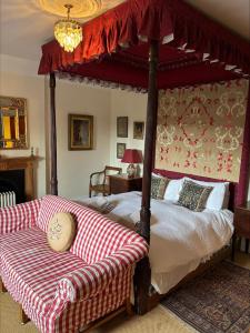 a bedroom with a canopy bed and a couch at Cambus O' May Traditional Highland Hotel in Ballater
