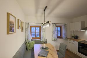 a living room with a table and a kitchen at Bachbauer am Attersee in Weyregg