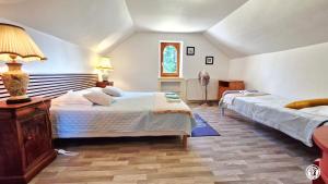 a bedroom with two beds and a lamp at Ecluse Mingot in Châtillon-en-Bazois