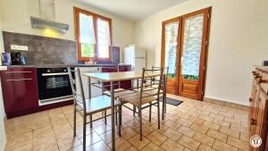 a kitchen with a table and some chairs in it at Ecluse Mingot in Châtillon-en-Bazois