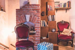 two chairs sitting in front of a brick fireplace at La Lune de Saint George in Hone