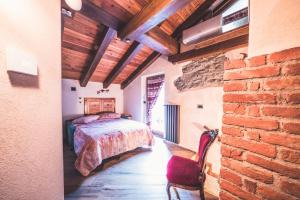 a bedroom with a bed and a brick wall at La Lune de Saint George in Hone