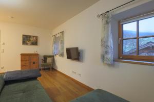 a living room with a bed and a window at Bachbauer am Attersee in Weyregg