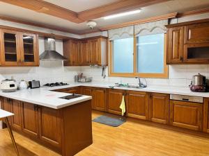 a kitchen with wooden cabinets and a large window at 파노라마 스테이 in Paranjang +51 photos