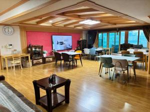 a large room with tables and chairs and a screen at 파노라마 스테이 in Paranjang