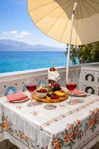a table with two glasses of wine and a plate of food at Moukas Seaside Apartments Romantico in Selianitika