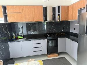 a kitchen with white cabinets and black appliances at Apartamento confortável in Santarém