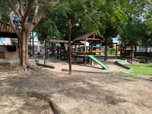 a park with a playground with a slide and trees at Apartamento confortável in Santarém