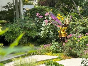a statue of a butterfly in a garden with flowers at 春江屿舍 in Xi'an