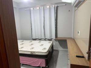 a small room with a bed and a window at Apartamento confortável in Santarém +7 photos