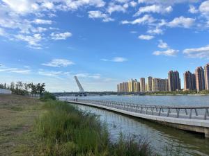 a bridge over a river in a city with tall buildings at 春江屿舍 in Xi'an