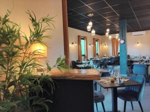 a restaurant dining room with tables and chairs at Hôtel Le Bratoria, anciennement Le Saint Vincent in Vourles